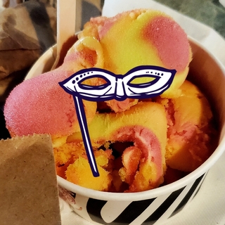Ice cream in a paper cup with a hand drawn mask on top of it