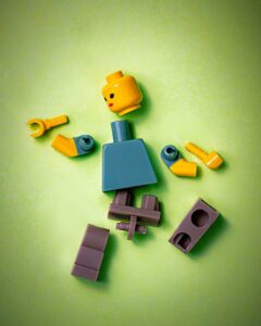 Disassembled LEGO figure on lime green background