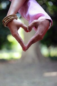 A hand heart made with two different people's hands