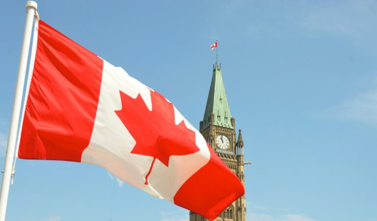 Canadian flag waving in front of the Parliament Building on Parliament Hill in Ottawa.