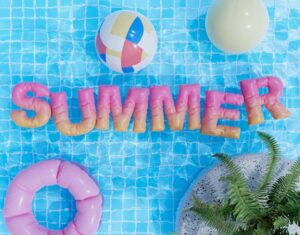 floaties in a pool spelling out the word summer