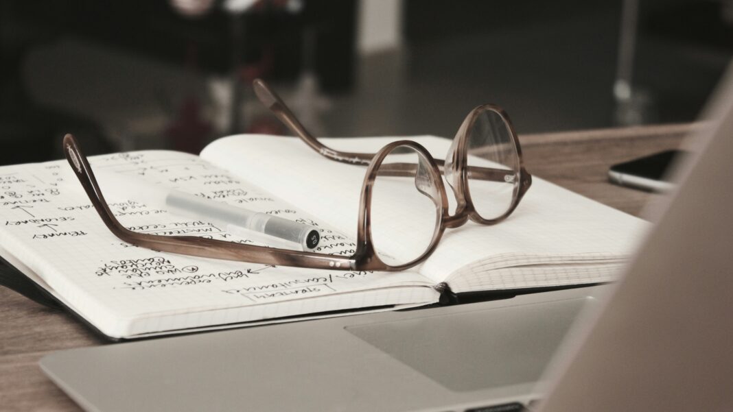 Eyeglasses with gray frames on the top of notebook photo - Free Business Image on Unsplash