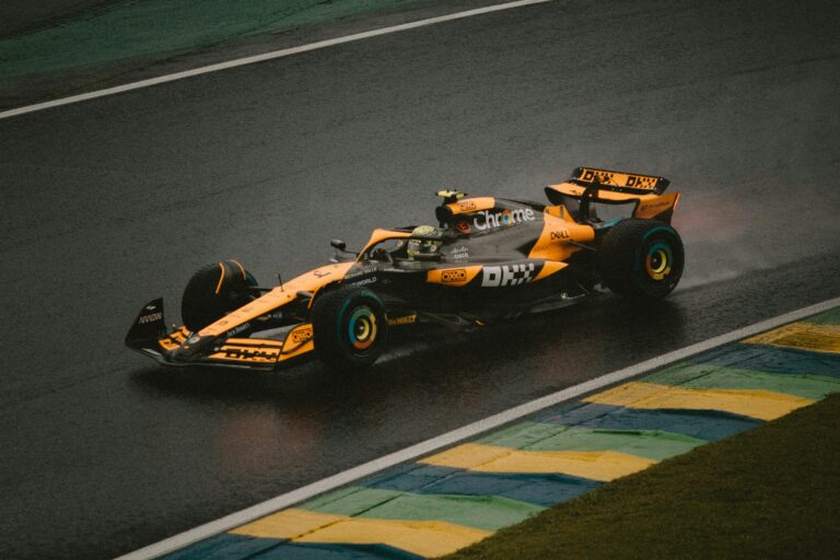 Formula 1 car racing on a wet track in the rain.