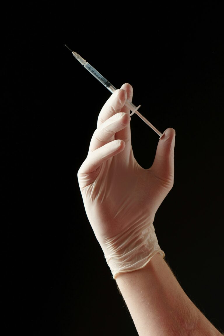 gloved hand carrying needle