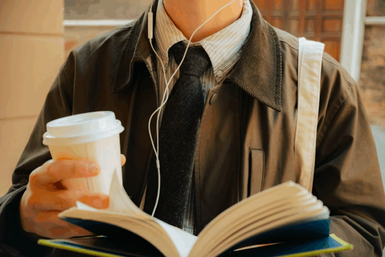 Man holding coffee cup and book with earphones - Man Image on Unsplash